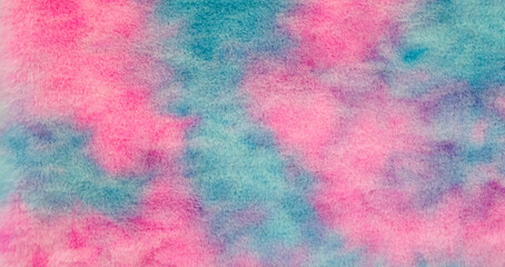 A colorful background with blue, pink and purple colors. The background is made of fuzzy material. The background is a mix of colors and it gives a sense of fun and playfulness