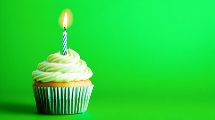 A delicious cupcake with white icing, sprinkles, and a lit candle on top, set against a vibrant green background, symbolizing celebration, joy, and festivity, blank space for text on backdrop