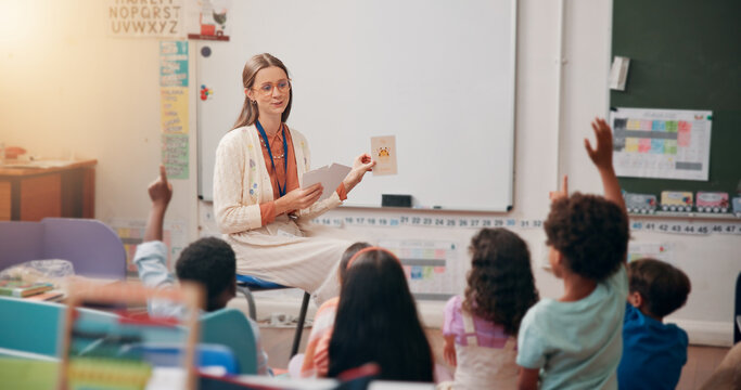 Teacher, children and hand raised in classroom for question, answer and quiz card for education at academy. Woman, kids and test for animal, happy and development with learning at elementary school