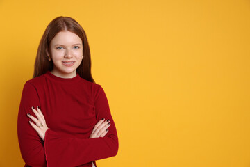 Fototapeta premium Teenage girl wearing stylish jewellery on yellow background, space for text
