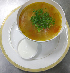 chicken broth or soup with vegetables and quail meat in a round plate, top view. Homemade healthy food - cooking fresh chicken or quail soup