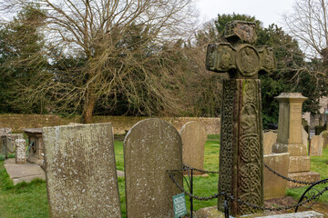 Eham, Chesterfield, United Kingdom - 21 Mar 2025 - A cemetery with a cross and several gravestones. The cross is in the middle of the cemetery and is surrounded by a chain link fence. The cemetery is 