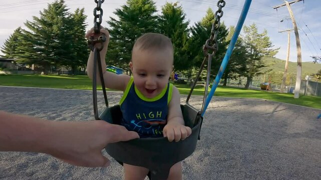Happy Baby Boy Laughs on a Swing Set in British Columbia Park