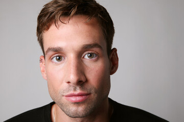 Fototapeta premium Close-up headshot of handsome man wearing casual clothing posing over white background. Mental health.