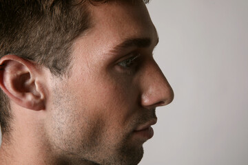 Obraz premium Profile portrait of young handsome man with serious face expression looking at the camera. Mental health.