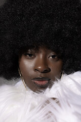 Close-up of stunning African American young woman with afro hair posing over white background....