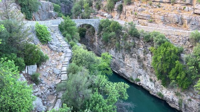 The historic Roman Oluk Bridge, or Eurymedon Bridge, in Koprulu Canyon. The ancient Roman bridge was built across the turquoise Kopruchai River in emerald green color.The National Park.Antalya,Turkey
