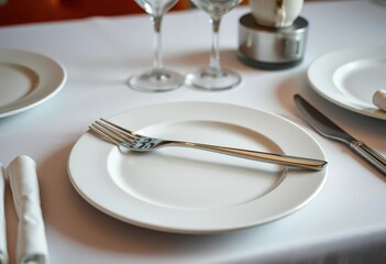 Clean white plate with elegant silverware, minimalist table setting, texture, silverware