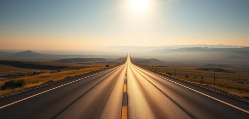 Fototapeta premium Endless asphalt ribbon vanishing into hazy distance, sun-drenched landscape, travel photography, horizon