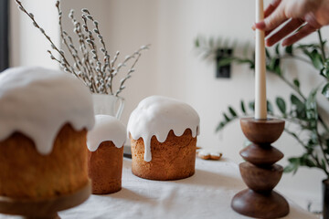 A stylish and aesthetically pleasing table with Easter pastries and festive decor. Easter cake, Easter eggs, candles. Copy space