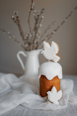 Easter table decorated with a homemade Easter cake on a stand, painted eggs and candles, morning light, natural colors, festive mood