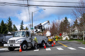 Utility digger derrick truck with pole setting equipment, ready to remove temporary wood powerline pole, infrastructure upgrade supporting new housing development
