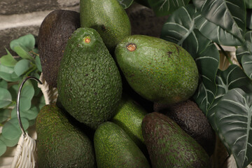 Fresh Ripe Avocados in a Basket with Decorative Greenery