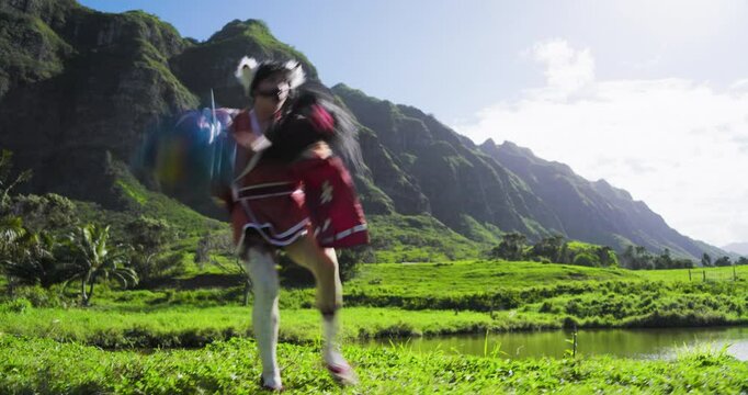 Epic woman in fantasy costume smacking guy in panda costume and sending him flying on wires through tropical area - low shot