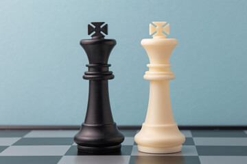 Black and white king chess pieces standing on a chessboard