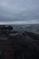 Fototapeta premium Rocky coastline with cloudy sky in the morning.