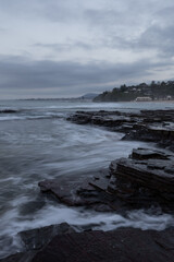 Cloudy morning view along rocky beach coastline.