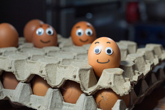 Eggs with smiley faces. Fun breakfast for kids. Fresh egg carton. National Egg Day concept. - Powered by Adobe