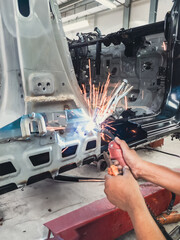a man is welding the frame of a car that is being repaired