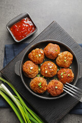 Tasty meatballs served on grey table, flat lay