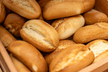Freshly baked bread rolls in a wooden basket, perfect for breakfast or bakery product marketing, delicious golden crust and soft texture. Mini bread baguettes in basket. pieces to accompany food