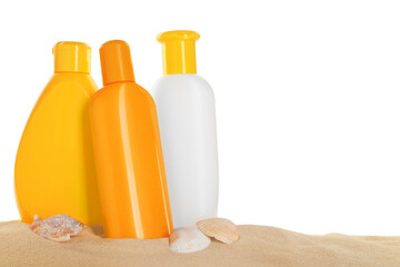 Different sun protection products and seashells on sand against white background