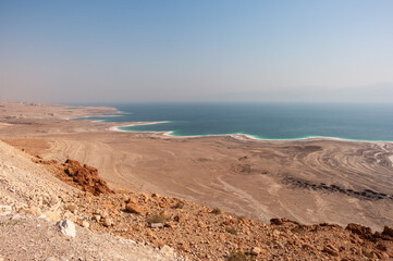 A desert landscape with a body of water in the distance