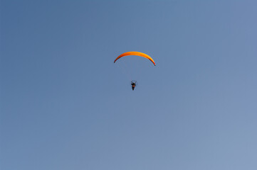 A man is flying a parachute in the sky