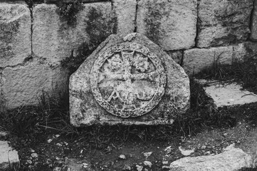 A stone slab with a cross on it sits on the ground