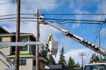 Utility digger derrick truck with pole setting equipment, lineman in lift bucket, ready to remove temporary wood powerline pole, infrastructure upgrade supporting new housing development  © knelson20