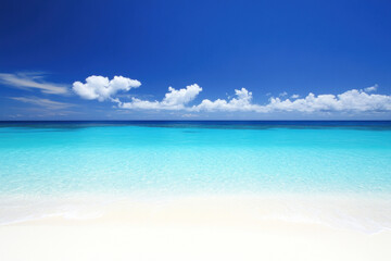 Obraz premium A serene beach scene with crystal clear turquoise waters and a white sandy shore, under a bright blue sky with few scattered clouds