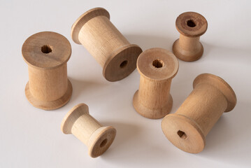 Wooden Thread Spools Scattered on White Background