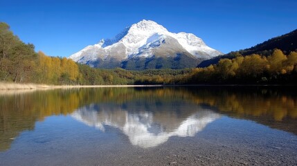 Naklejka premium Majestic mountain reflected in a serene lake. Autumnal foliage surrounds the tranquil water