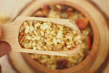 Wooden scoop holds grains of bulgur ready for cooking and nutrition