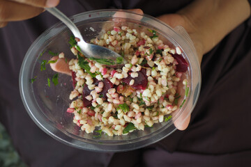 Fresh grain salad with beets and herbs served in a bowl