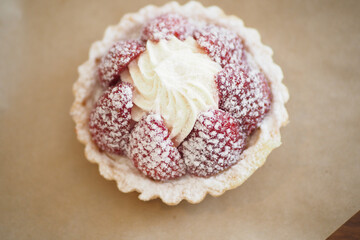 Freshly baked raspberry tart with whipped cream topping
