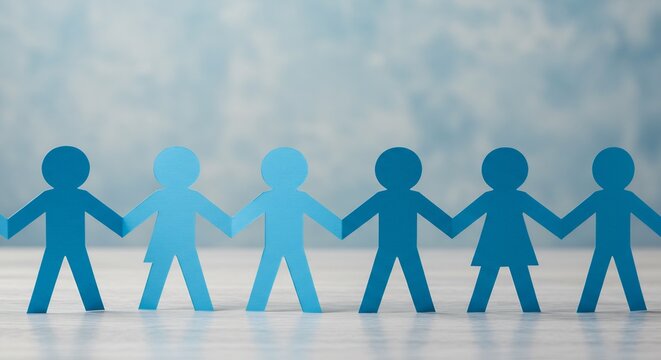 Unity and Teamwork: A Row of Interconnected Blue Paper Chain People Figures on a Light Gray Surface Against a Soft Blue Background