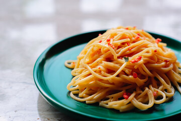 A close-up of a plate of spaghetti carbonara with a creamy sauce and crispy bacon bits.