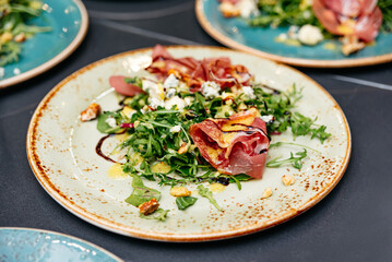 Gourmet arugula salad with prosciutto and blue cheese.