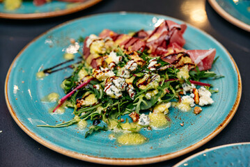 Arugula salad with prosciutto, blue cheese, and balsamic glaze.