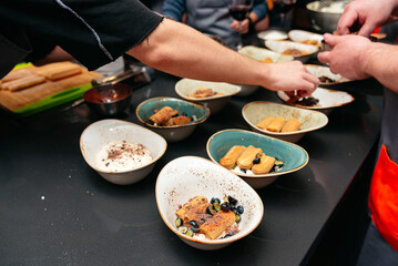 Group preparing gourmet desserts in a kitchen.
