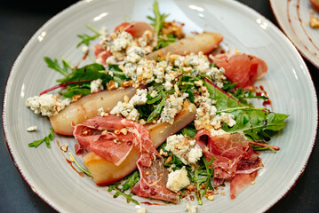 Gourmet arugula salad with poached pears and blue cheese.