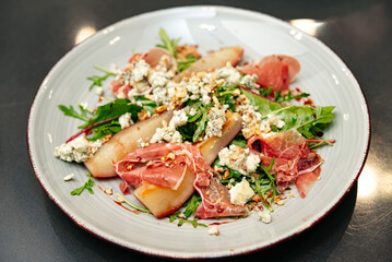 Gourmet salad with poached pears and prosciutto.
