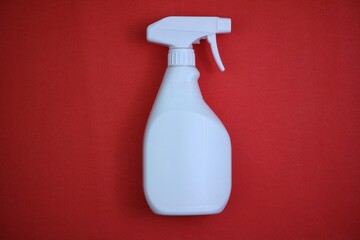 White Spray Bottle on Red Background. top view