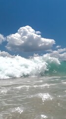 Fototapeta premium Stunning Ocean Wave Crashing Under Blue Sky with Fluffy Clouds