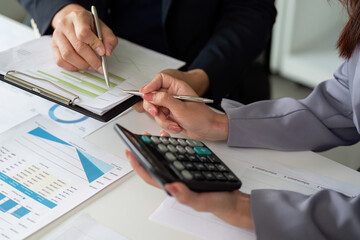 Teamwork and Financial Planning. Colleagues reviewing financial charts and calculations together.