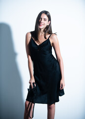 Young woman photographer in studio. Charming photographer takes a shot with camera. Fashion beautiful girl with camera. Pretty woman is a professional photographer with dslr camera.