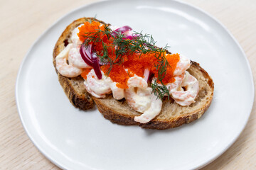 A plate of prawn toast on sourdough bread.