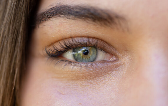 Close-up of woman's eye with green iris, capturing detail and emotion