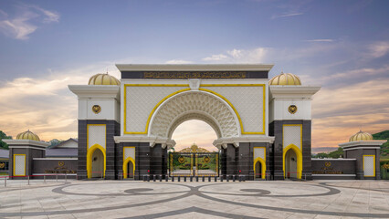 The grand entrance of Istana Negara stands majestically against a colorful sunset. This royal palace in Kuala Lumpur, Malaysia represents Malaysia's cultural heritage and architectural elegance © Khaled El-Adawi